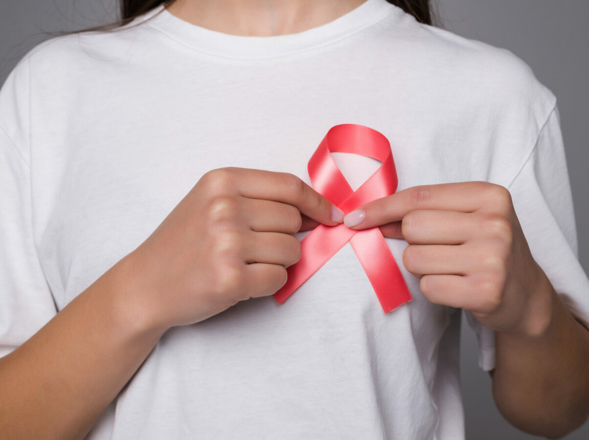 World Breast Cancer Day Concept,health care - woman wore white t-shirt with Pink ribbon for awareness, symbolic bow color raising on people living with women's breast tumor illness